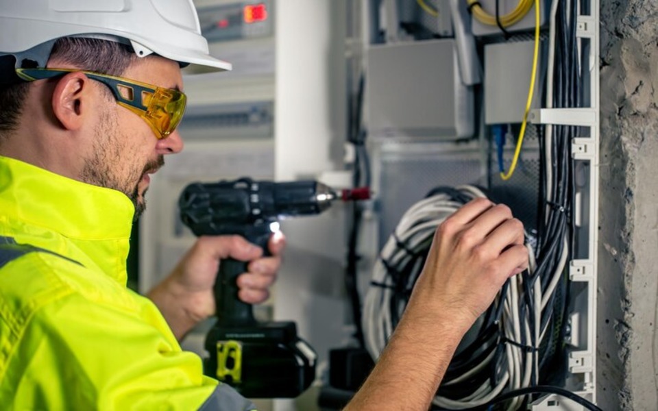 Man electrical technician working switchboard with fuses 169016 24583 (1)
